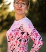 Zbliżenie rękawa i przodu longsleeve’u damskiego Sakura LOCO, widoczne różowe logo na ramieniu i kwiaty wiśni.