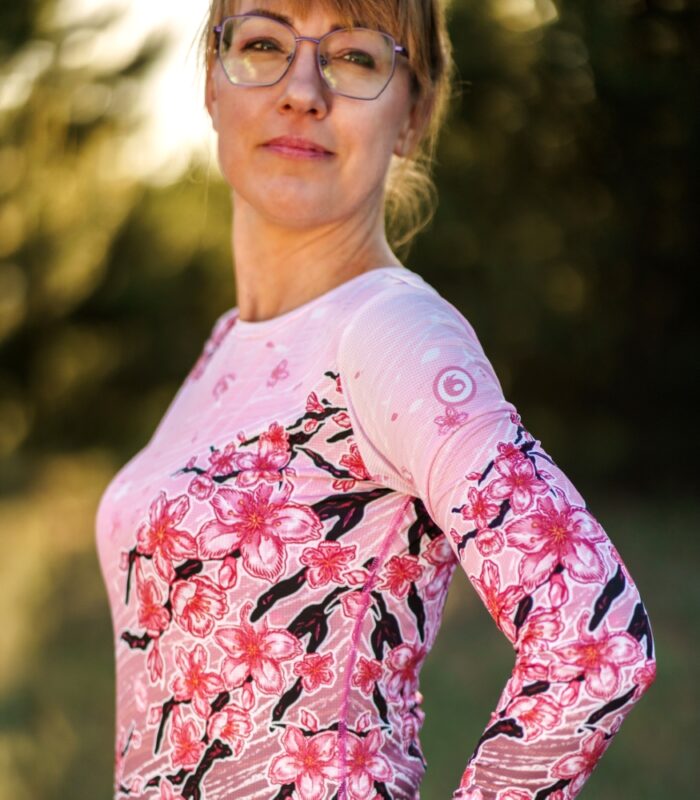 Zbliżenie rękawa i przodu longsleeve’u damskiego Sakura LOCO, widoczne różowe logo na ramieniu i kwiaty wiśni.