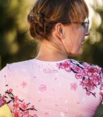 Zbliżenie górnej części pleców longsleeve’u Sakura LOCO, widoczne różowe logo pod dekoltem i gałązki z kwiatami wiśni.