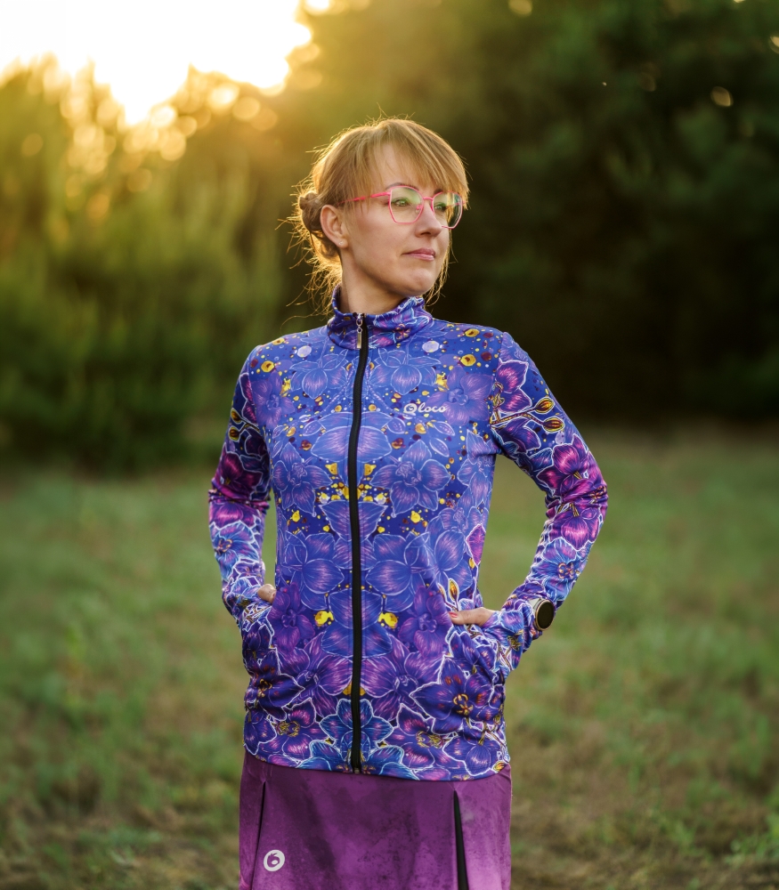 Bluza damska Nocna Orchidea LOCO – przód i kieszenie Damska bluza sportowa Nocna Orchidea LOCO z zamkiem i stójką, modelka trzyma dłonie w bocznych kieszeniach.