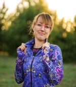 Bluza Nocna Orchidea LOCO na modelce z częściowo rozpiętym zamkiem, widoczna stójka i fioletowe kwiaty.