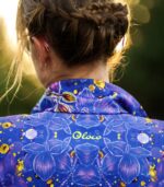 Zbliżenie stójki i górnej części pleców bluzy Nocna Orchidea LOCO, widoczne żółte logo oraz kwiatowy wzór.
