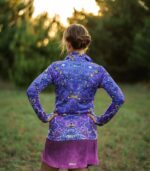 Bluza sportowa damska Nocna Orchidea LOCO na modelce z tyłu, widoczny krój, stójka i wzór kwiatów na plecach.