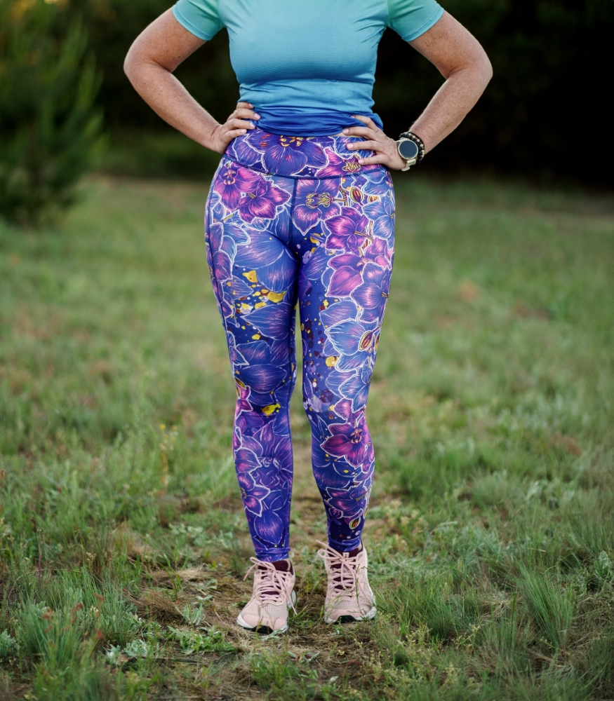 Długie legginsy damskie Nocna Orchidea LOCO – widok z przodu Długie legginsy sportowe damskie Nocna Orchidea LOCO na modelce z przodu, widoczny szeroki pas i wzór orchidei.