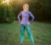 Damski longsleeve sportowy Nocna Orchidea LOCO w fioletowo-niebieskie kwiaty, cała sylwetka modelki w plenerze.