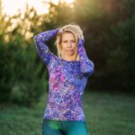 Longsleeve damski Nocna Orchidea LOCO na modelce z uniesionymi rękami, widoczny przód koszulki i wzór orchidei.