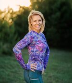 Damski longsleeve Nocna Orchidea LOCO na modelce z boku, widoczny dopasowany krój, długi rękaw i fioletowe kwiaty.