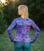 Longsleeve sportowy damski Nocna Orchidea LOCO na modelce z tyłu, widoczny krój, długie rękawy i wzór kwiatów na plecach.
