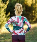 Damski longsleeve sportowy Liściak LOCO na modelce, widok z tyłu z kolorowym wzorem liści i logo pod karkiem.