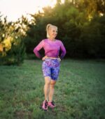 Krótkie legginsy damskie Nocna Orchidea LOCO w fioletowo-niebieski wzór kwiatów, cała sylwetka modelki w plenerze.