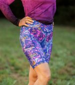 Krótkie legginsy sportowe damskie Nocna Orchidea LOCO na modelce z ukosa, widoczny szeroki pas, boczna kieszeń i żółte logo.